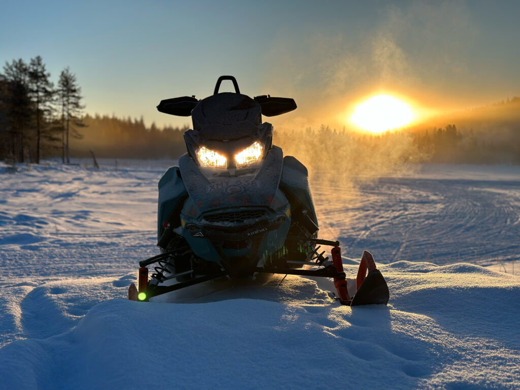 Schneemobil Skidoo Freeride 850 nach Schneemobiltour in Position gestellt vor Sonnenuntergang in schwedisch Lappland.